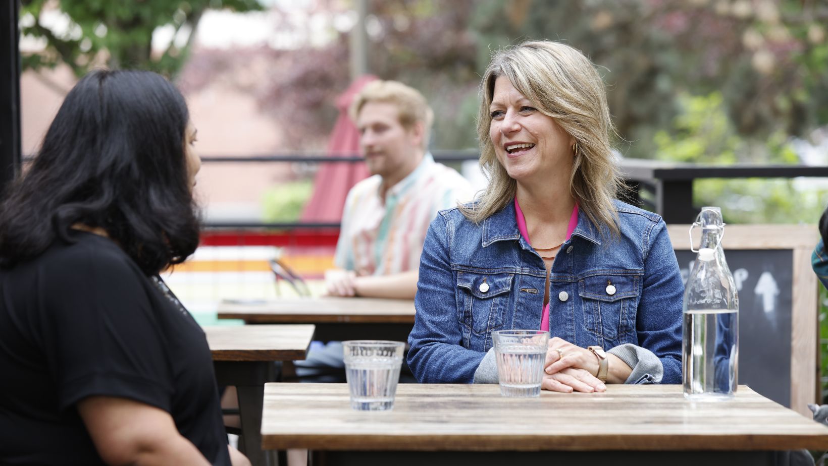 Angela in a conversation at an outdoor table